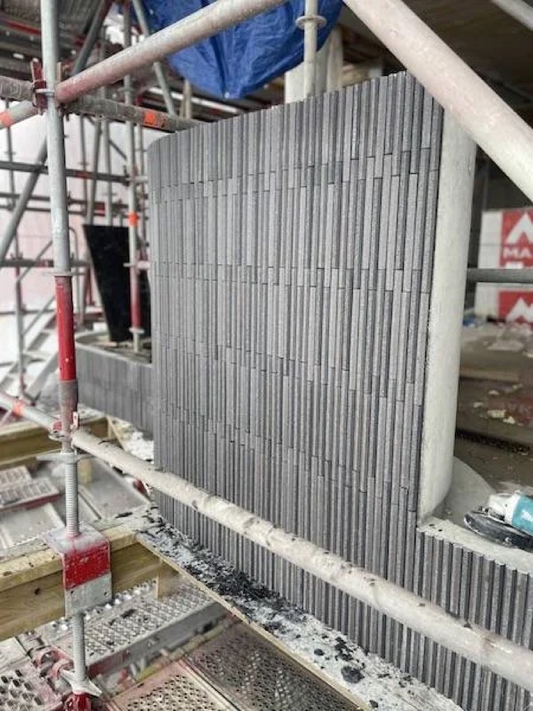 Afgewerkt vlak met grijze steenstrips in een verticaal legpatroon tussen de steigers bij De Hoogh Amsterdam