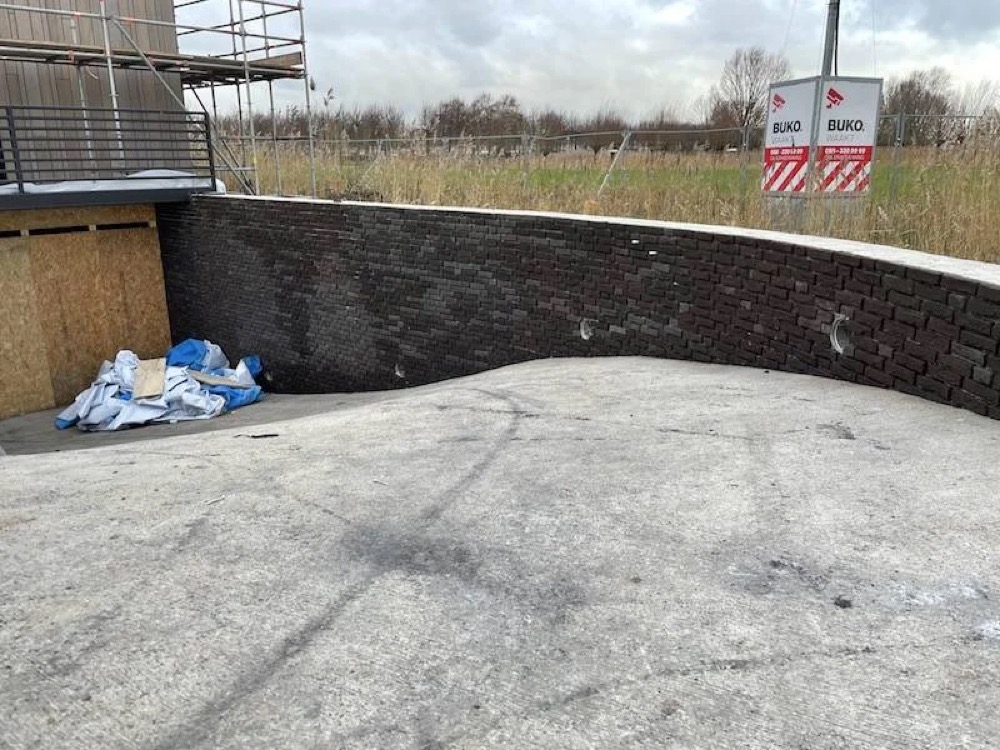 Lage betonnen muur met een afdekplaat bij het project in Alkmaar