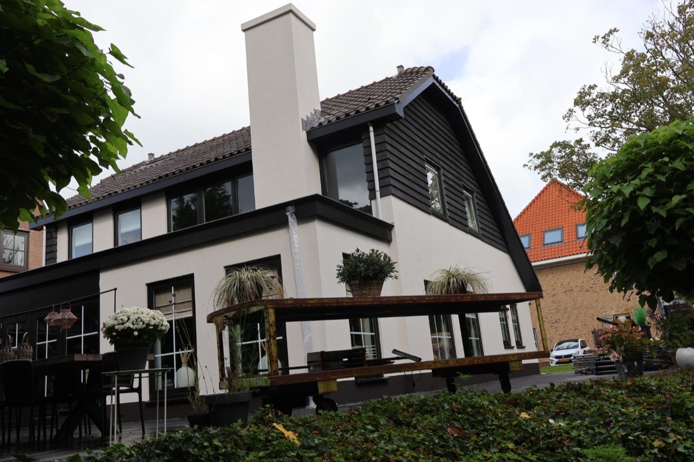 Villa in Koedijk met witte sierpleister, een antraciet plint en een witte schoorsteen