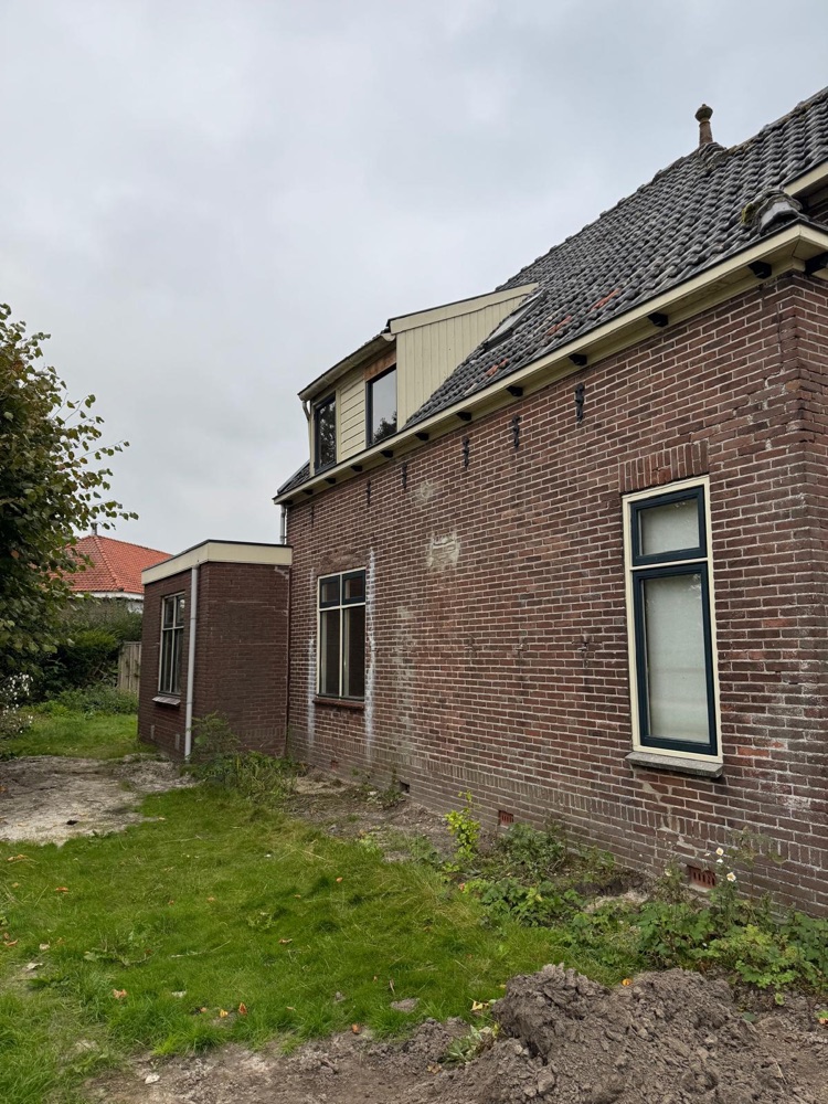 Bakstenen zijgevel van de woning in Spanbroek vóór de buitengevelisolatie