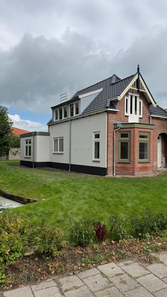 Woning in Spanbroek na het werk, met witte sierpleister naast de bakstenen erker