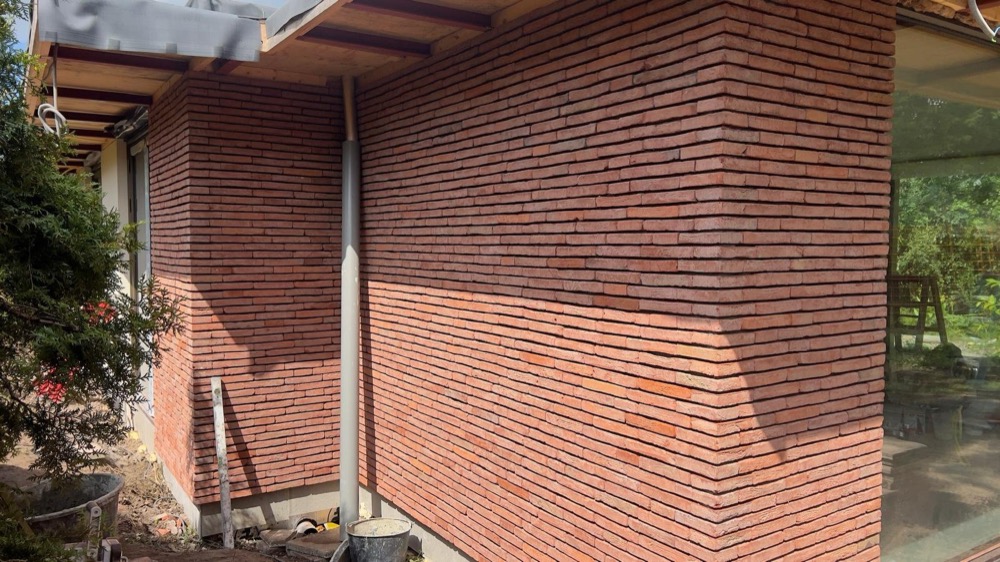 Gevel met rood-bruine steenstrips bij een woonhuis in Amsterdam-Noord