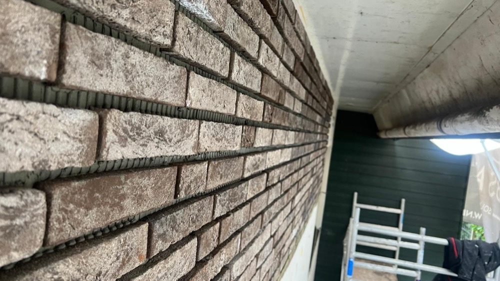 Close-up van de steenstrips tegen de dakrand bij het woonhuis in Andijk