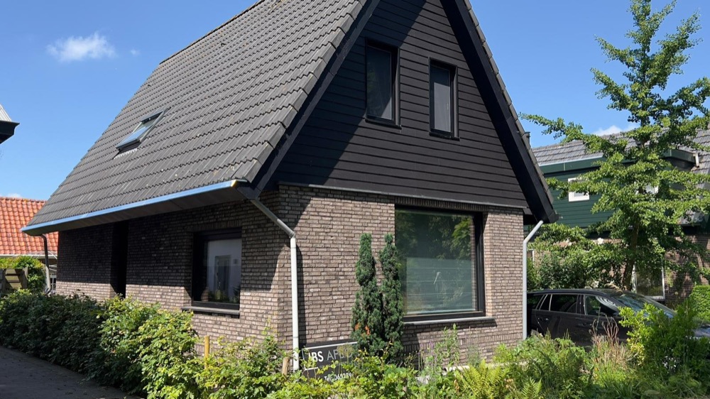 Afgewerkt woonhuis in Andijk met een gevel van steenstrips in gemêleerde bruintinten