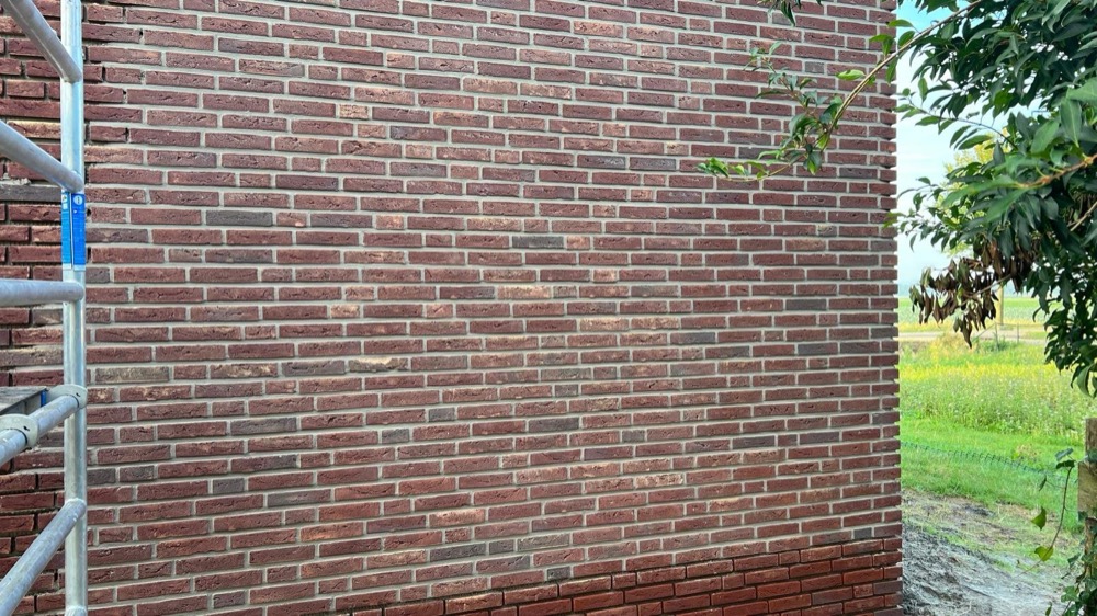 Gevelvlak met steenstrips en een steigerpijp in Langedijk